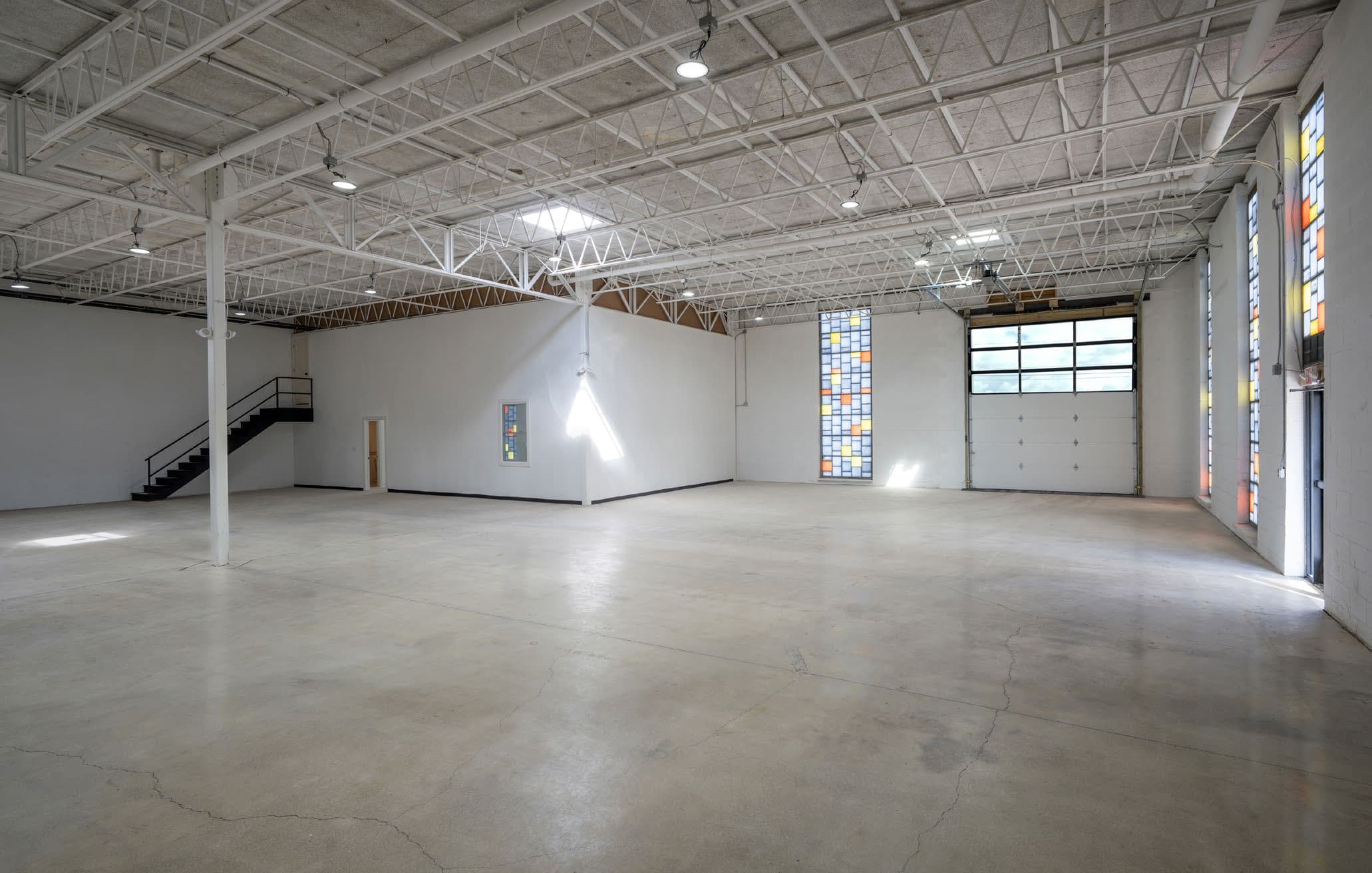 Polished concrete warehouse floor with stairs and accent glass block windows